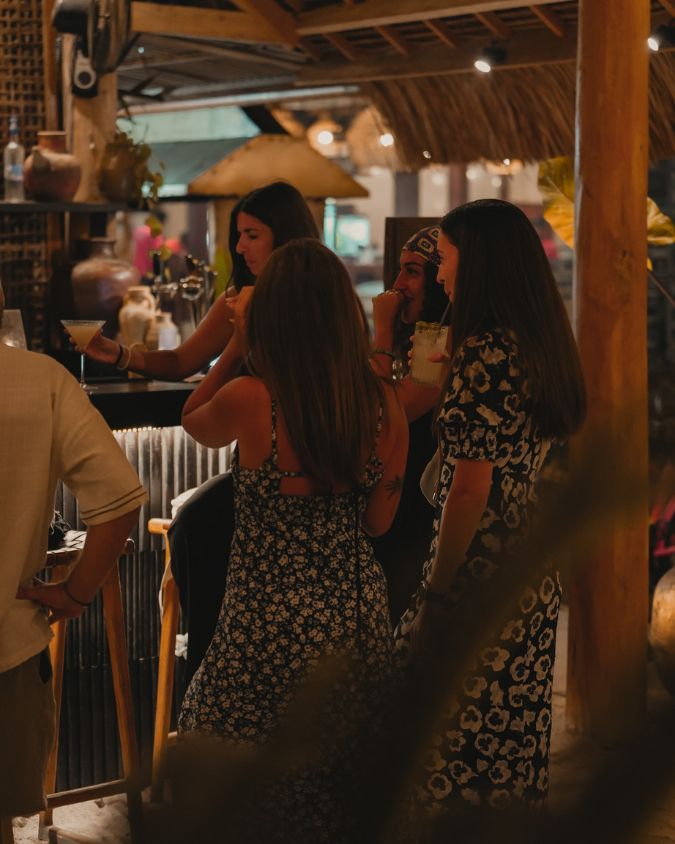 Guests socializing while having cocktails at Bahia Gili Air